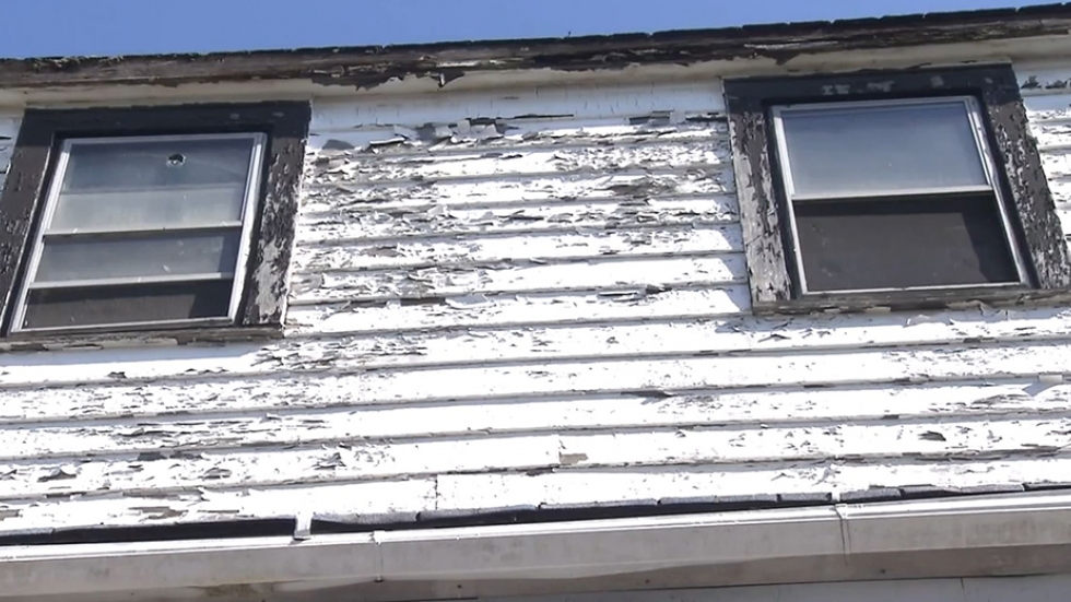 Ruined white painting of a home