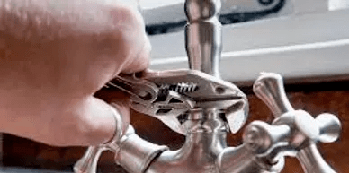 A wrench tightening the faucet